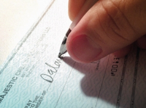 Closeup of a person's hand writing a check